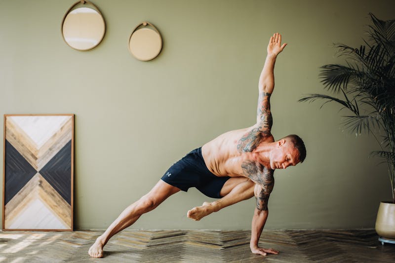 Person holding a balance pose on a mat in a bright minimalist room